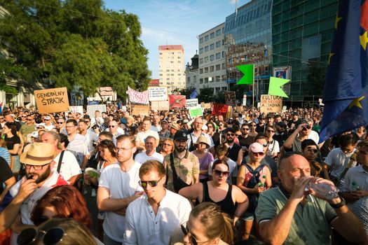 Rassemblement de manifestants lors d'une marche féministe, portant des pancartes et affichant des signes de solidarité.
